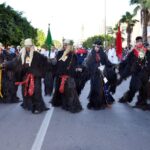 أشخاص يرتدون أزياء تنكرية ملونة في استعراض كرنفالي