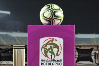 لاعبو كرة القدم يتنافسون على الكرة في مباراة بالدوري المغربي.