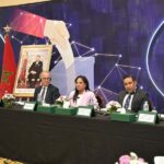 رجال يجلسون في مؤتمر يناقشون التعاون الرقمي.