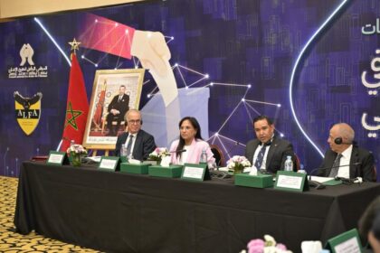 رجال يجلسون في مؤتمر يناقشون التعاون الرقمي.