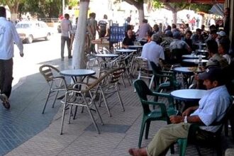 طاولة مقهى في الشارع العام بجانب بناية سكنية.