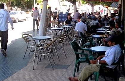 طاولة مقهى في الشارع العام بجانب بناية سكنية.