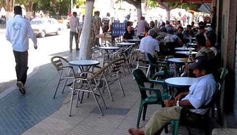 طاولة مقهى في الشارع العام بجانب بناية سكنية.