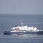 سفينة سياحية تبحر في المحيط الأزرق مع طوق نجاة.