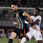 لاعب كرة قدم باللون الأبيض يحاول كسر تمريرة لاعب آخر