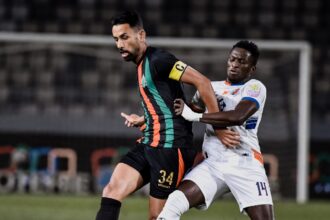 لاعب كرة قدم باللون الأبيض يحاول كسر تمريرة لاعب آخر