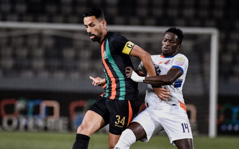 لاعب كرة قدم باللون الأبيض يحاول كسر تمريرة لاعب آخر