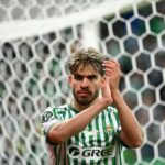 لاعب كرة قدم يرتدي زي GREE يصفق بيديه.