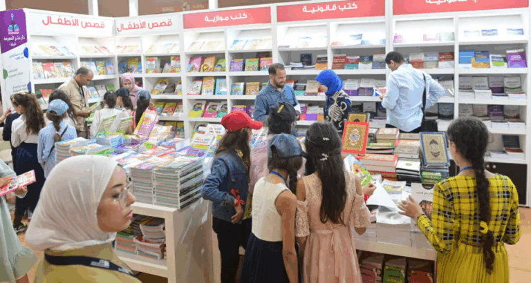 فتيات يشاهدن الكتب على رفوف مكتبة المعرض
