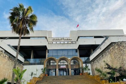 مبنى كبير تحت السماء مع شجرة