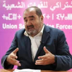 رجل يلقي خطابا أمام لافتة بنفسجية