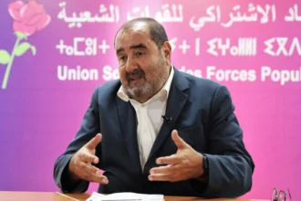 رجل يلقي خطابا أمام لافتة بنفسجية