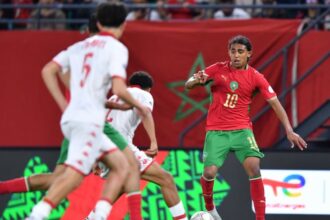 لاعب مغربي يراوغ بالكرة في مباراة كرة قدم.