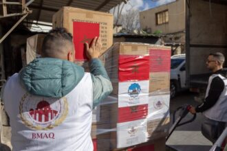 أشخاص يحملون صندوق مساعدات بمستشفى متنقل في القدس.