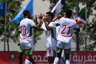 لاعبون مغاربة يتبادلون التحية في مباراة كرة قدم.