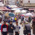 سوق شعبي مغربي يظهر الحركة اليومية والتفاعل التجاري.