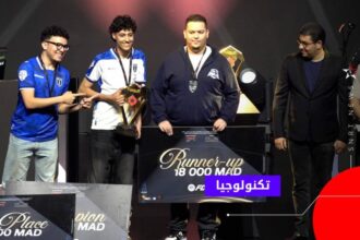 أشخاص يحملون شيكات الفوز في مسابقة ألعاب إلكترونية.