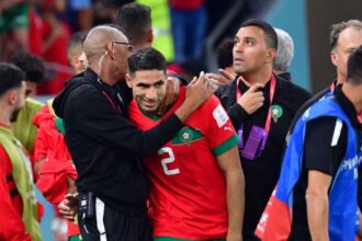 لاعب مغربي يحتفل مع الإداري بعد الفوز في كأس العالم