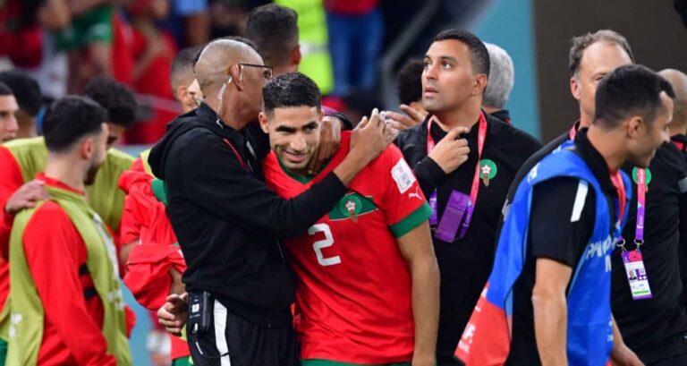 لاعب مغربي يحتفل مع الإداري بعد الفوز في كأس العالم