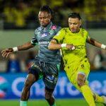 لاعب الرجاء يتصارع على الكرة مع لاعب المغرب الفاسي.