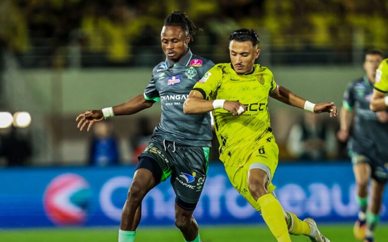 لاعب الرجاء يتصارع على الكرة مع لاعب المغرب الفاسي.