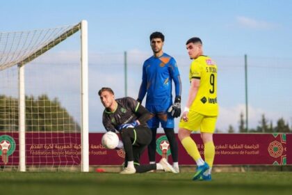 لاعب كرة قدم بقميص أصفر يلعب كرة القدم