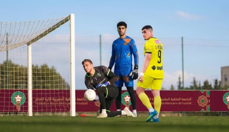 لاعب كرة قدم بقميص أصفر يلعب كرة القدم