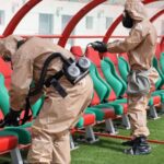 شخصان يرتديان بدلات حماية في الملعب