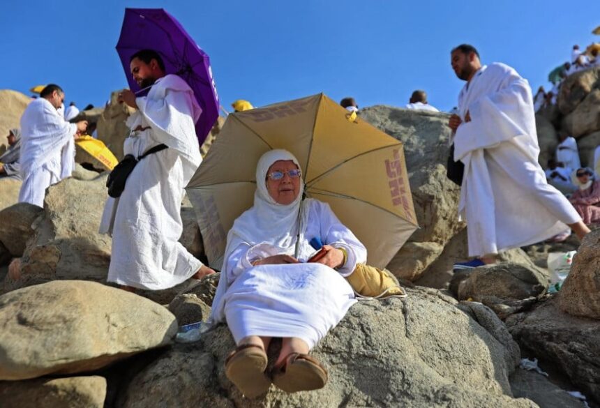 امرأة تجلس تحت مظلة في يوم حار بمكة المكرمة.