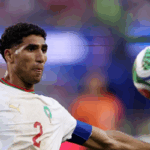 أشرف حكيمي يركض بالكرة في مباراة كرة قدم.