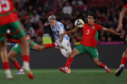 لاعب كرة قدم يرتدي القميص رقم 3 يسدد الكرة
