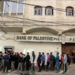رجال يصطفون أمام بنك فلسطين فرع رام الله.