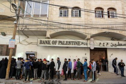 رجال يصطفون أمام بنك فلسطين فرع رام الله.