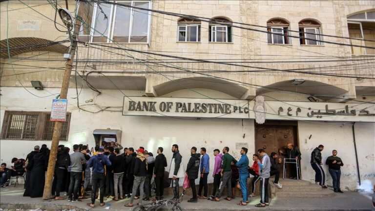 رجال يصطفون أمام بنك فلسطين فرع رام الله.