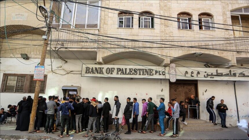 رجال يصطفون أمام بنك فلسطين فرع رام الله.