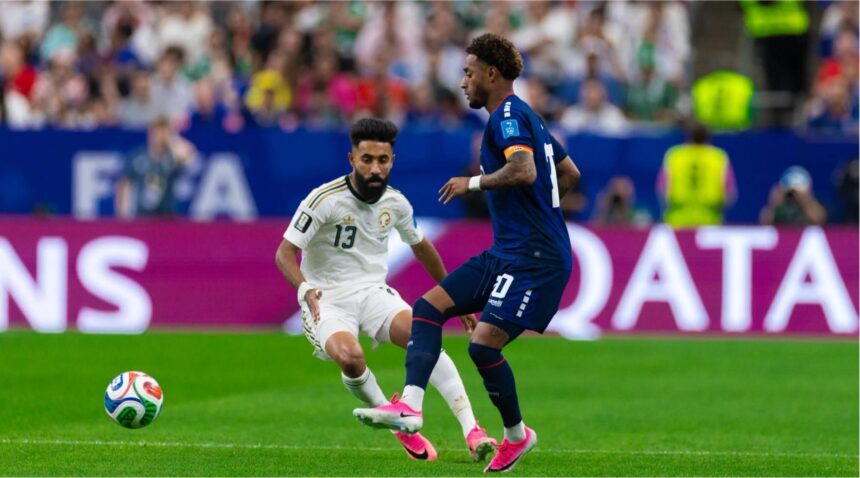 لاعب من الرأس الأخضر يراوغ لاعباً سعودياً في مباراة كرة قدم.
