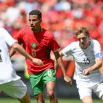 لاعب كرة قدم في الملعب يرتدي قميصاً أزرق ورقمه 8.
