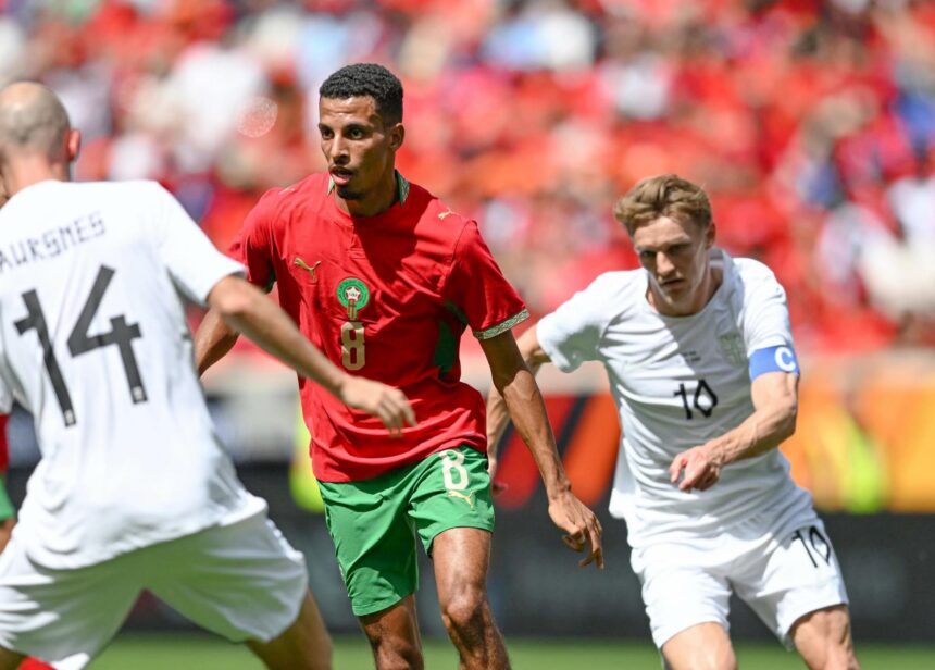 لاعب كرة قدم في الملعب يرتدي قميصاً أزرق ورقمه 8.