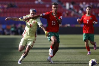 فؤاد الزهواني يرتدي قميص كرة قدم أحمر برقم 15.