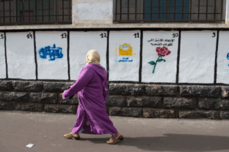 امرأة ترتدي عباءة التخرج البنفسجية بجانب بناء.