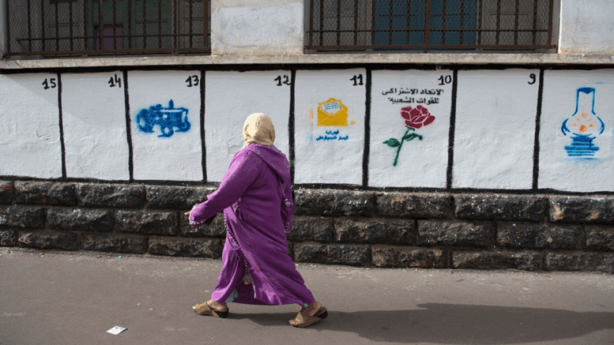 امرأة ترتدي عباءة التخرج البنفسجية بجانب بناء.