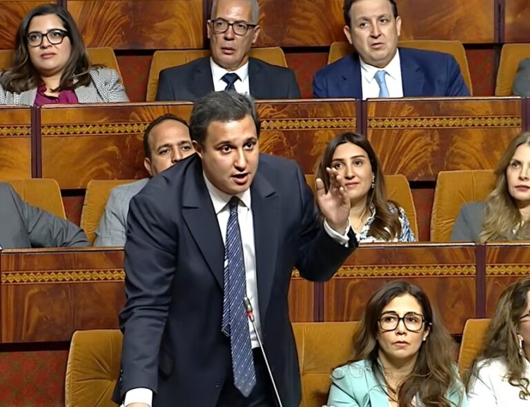رجل يرتدي بدلة زرقاء يتحدث في جلسة نقاش.