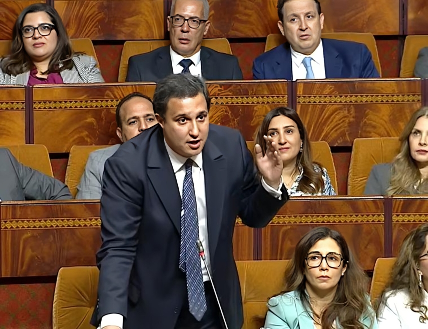 رجل يرتدي بدلة زرقاء يتحدث في جلسة نقاش.