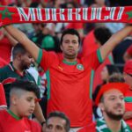 شخص يحمل قماشة عليها اسم المغرب