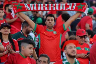 شخص يحمل قماشة عليها اسم المغرب