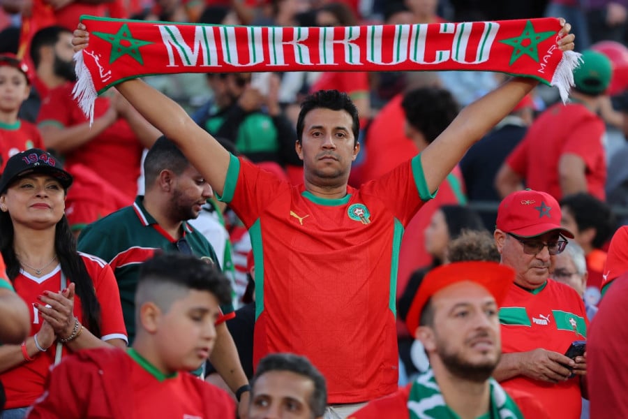 شخص يحمل قماشة عليها اسم المغرب