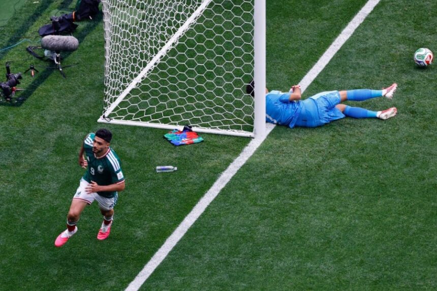 لاعب كرة قدم مكسيكي يسقط على الأرض وحارس جنوب إفريقيا ينظر.