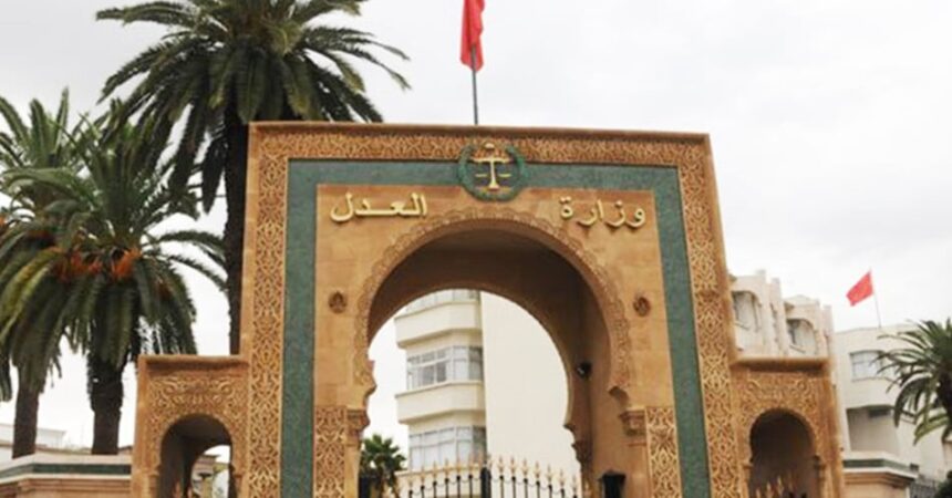 شعار وزارة العدل المغربية يعلو بوابة خشبية بنمط شمال أفريقي.