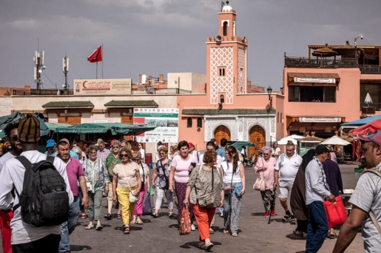 أشخاص يتجولون في سوق مزدحم محاط بالمباني التقليدية
