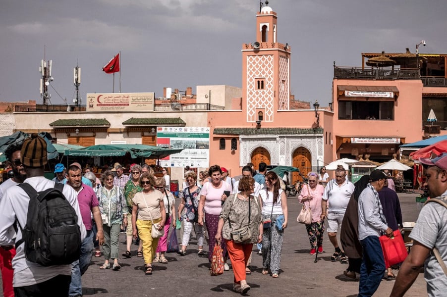 أشخاص يتجولون في سوق مزدحم محاط بالمباني التقليدية